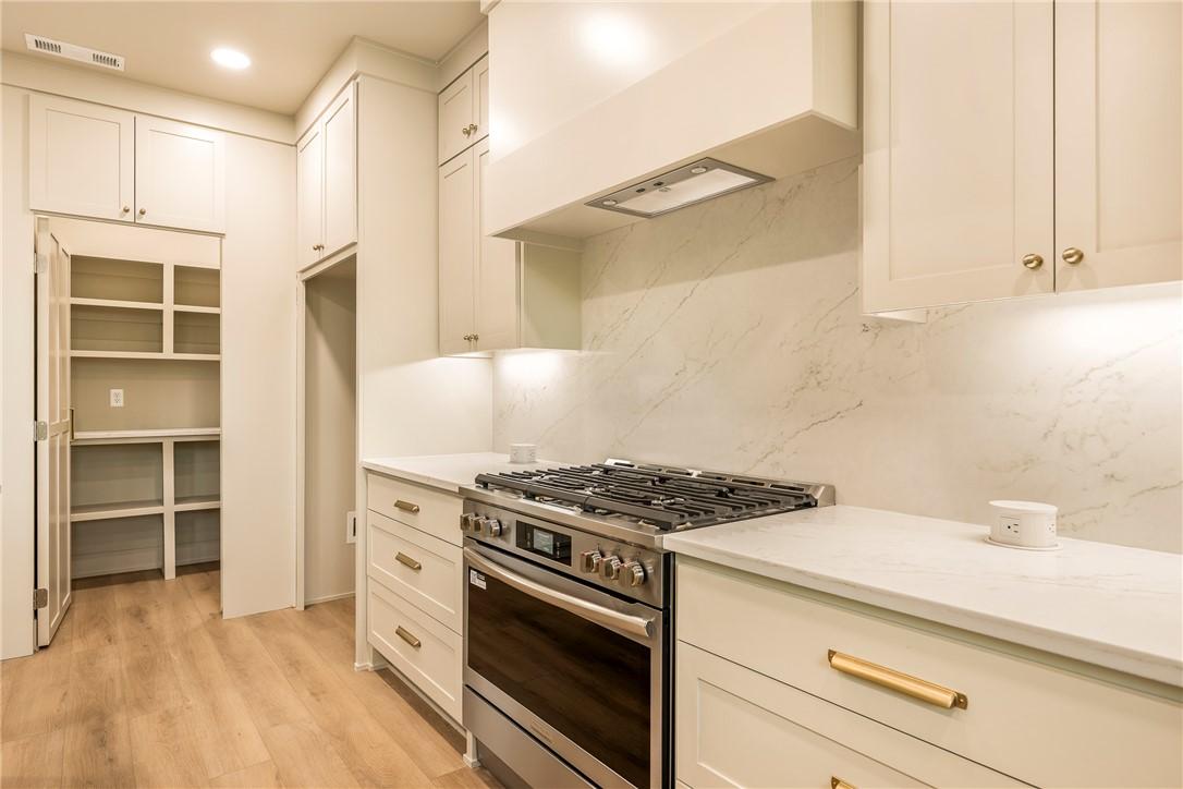 Image 4: Built-in pantry with shelving, wood-finish floorin