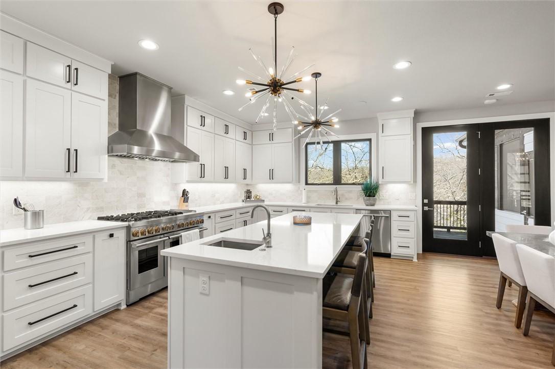 Image 4: Kitchen featuring a chandelier, appliances with st