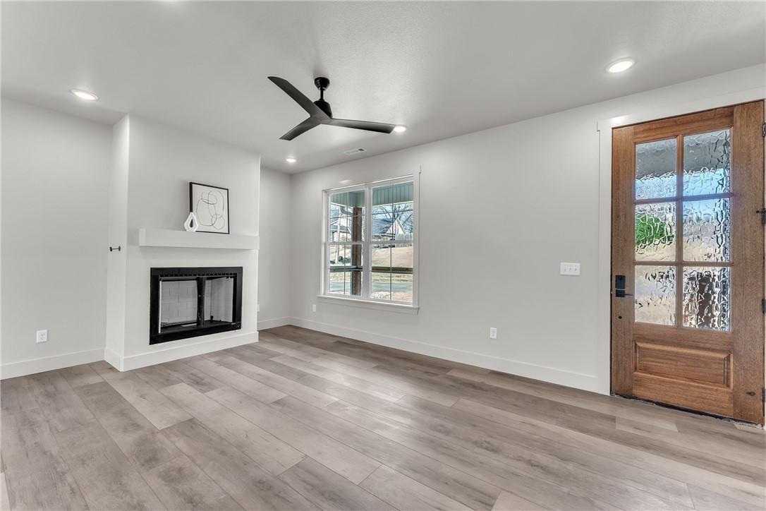Image 4: Spacious interior featuring wide plank wood-finish