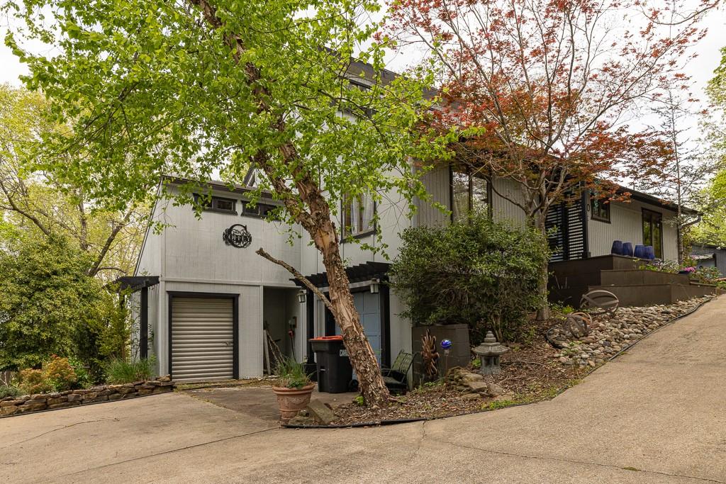 Image 1: The property features a concrete driveway, mature