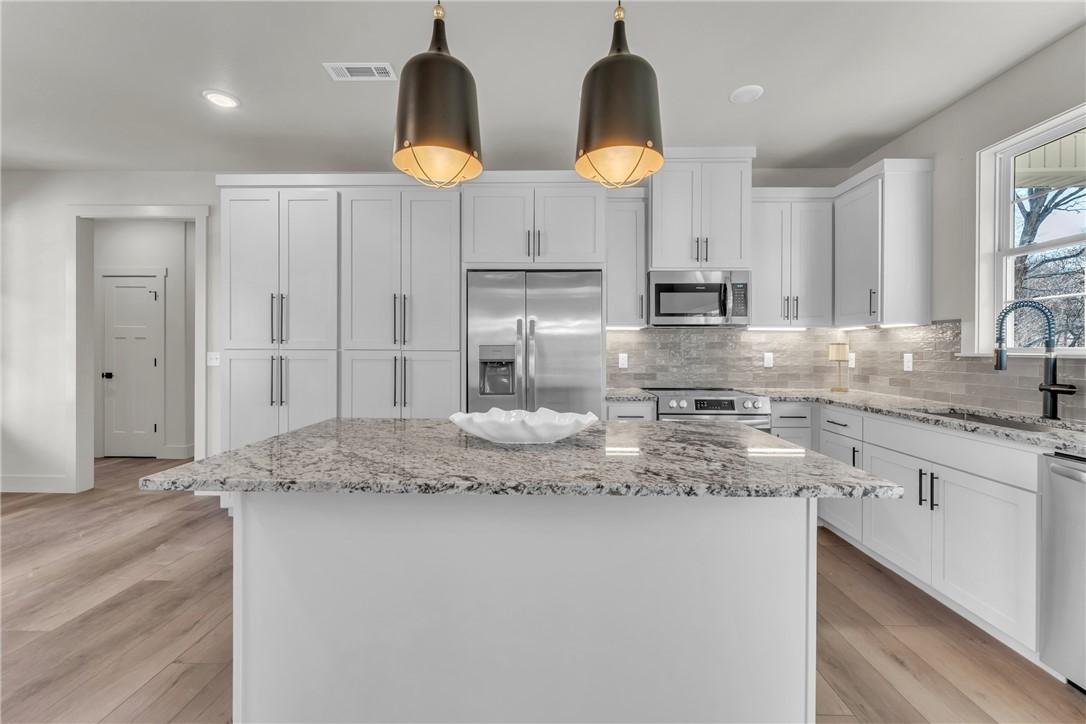 Image 4: Kitchen with a center island, appliances with stai