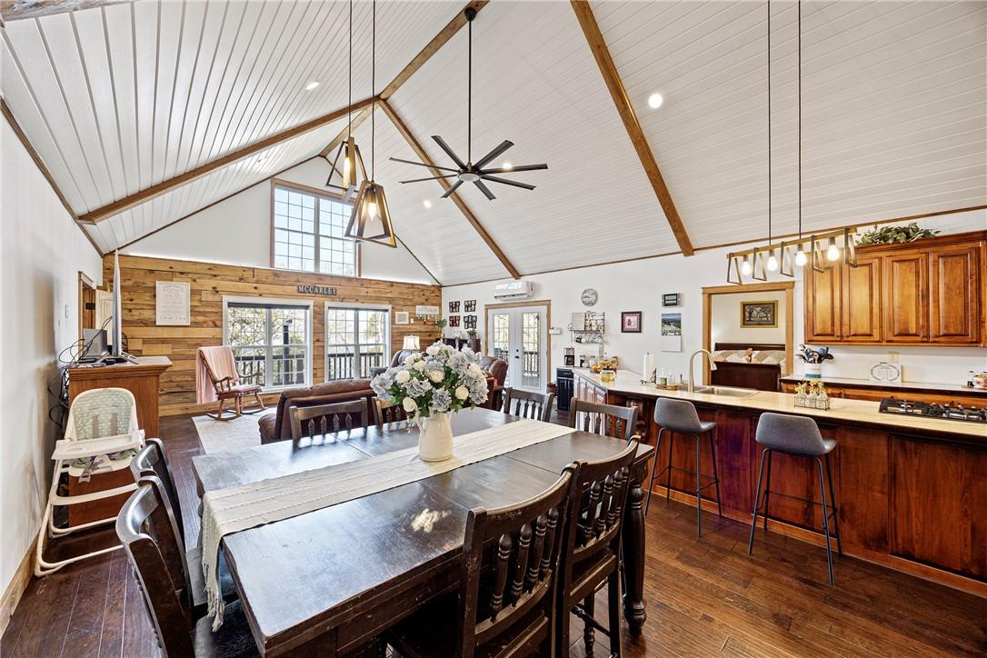 Image 4: Dining space featuring a ceiling fan, wood walls,