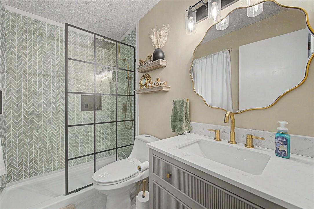 Image 1: Bathroom featuring a glass-enclosed shower with he