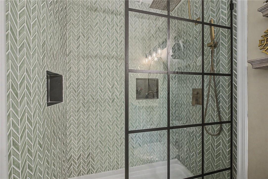 Image 2: Walk-in shower featuring a grid-patterned glass en