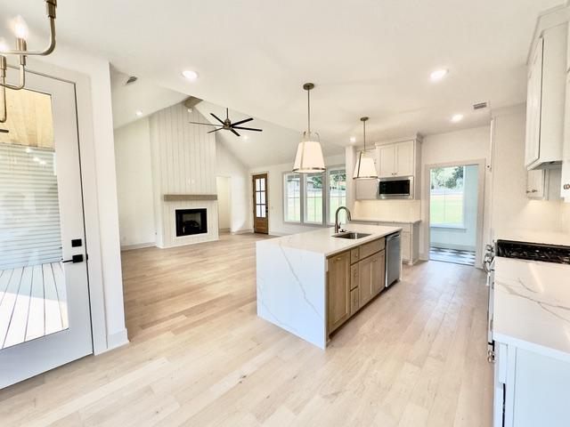 Image 4: Open-concept living area featuring a kitchen islan