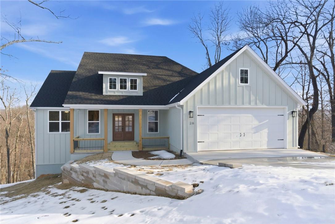Image 2: View of front of home with covered porch, board an