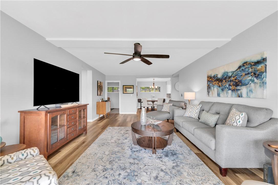 Image 2: Spacious living area featuring wood-finish floorin
