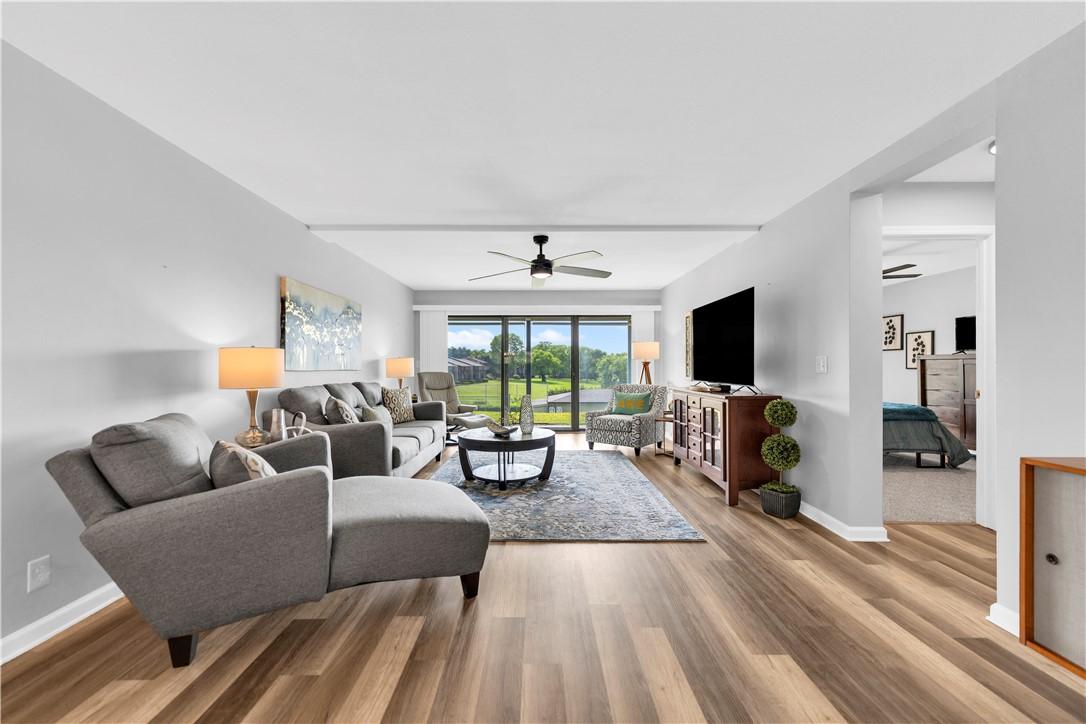 Image 3: Spacious living area featuring wood-finish floorin
