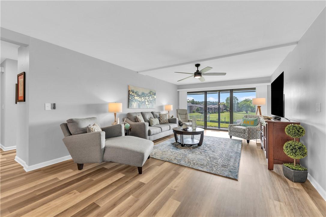 Image 4: Spacious living area featuring wood-finish floorin