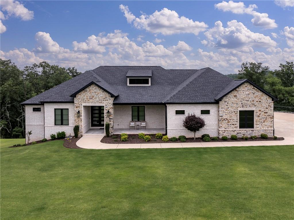 Image 1: Modern stone and brick exterior home with level en