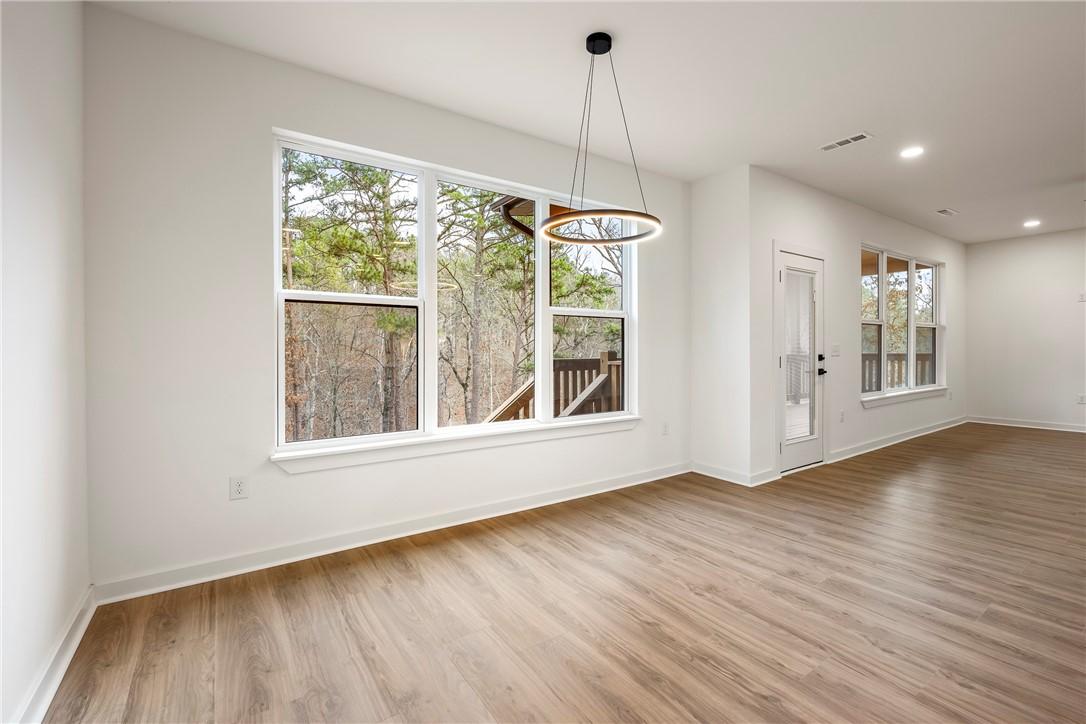 Image 3: Unfurnished dining area with light wood-type floor