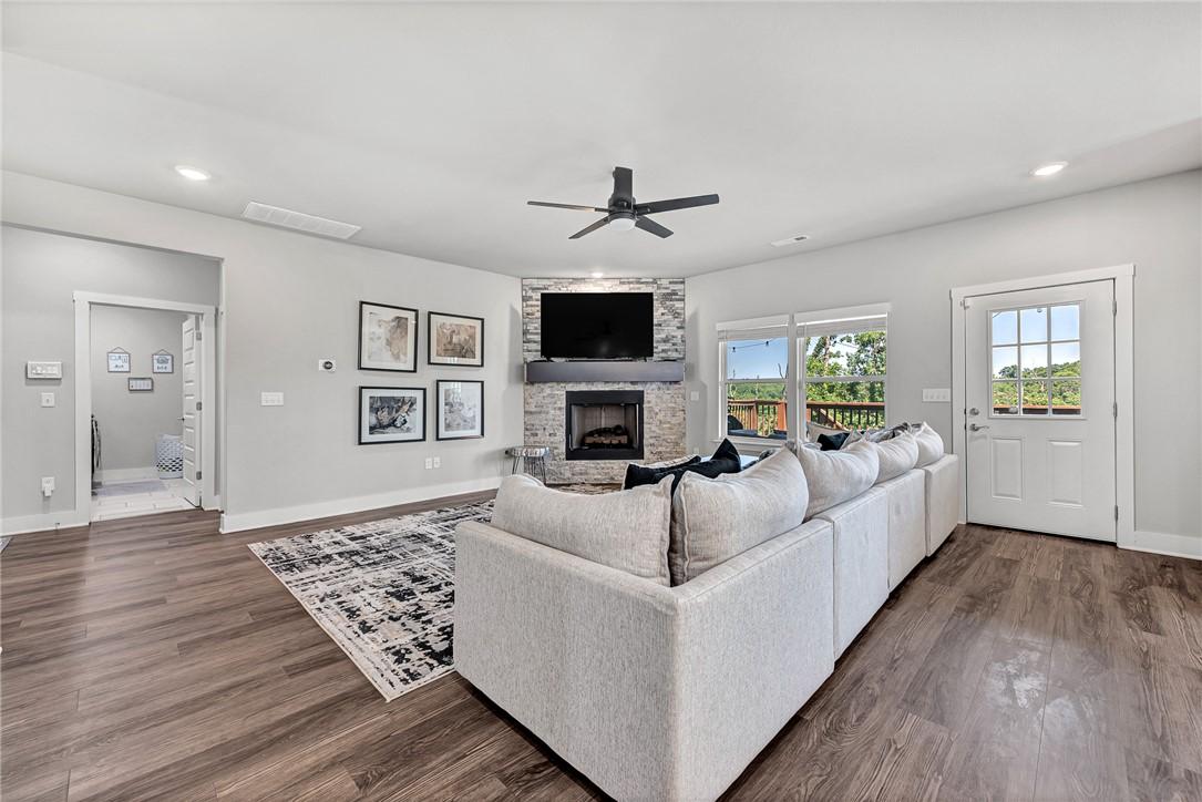 Image 1: Living area with ceiling fan, dark wood-style floo