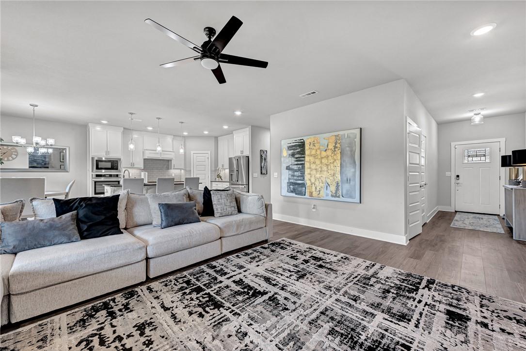 Image 2: Living area with ceiling fan, a chandelier, and da