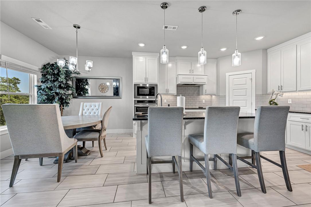 Image 3: Kitchen with white cabinets, a kitchen breakfast b