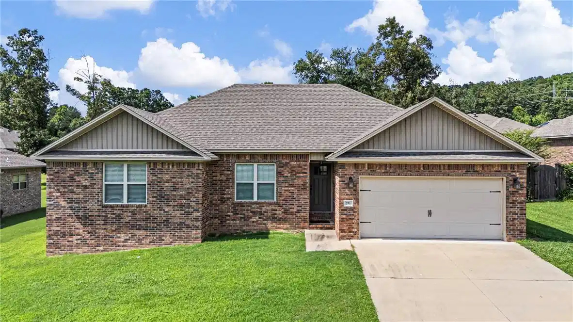 Image 1: Brick exterior residence featuring a two-car garag