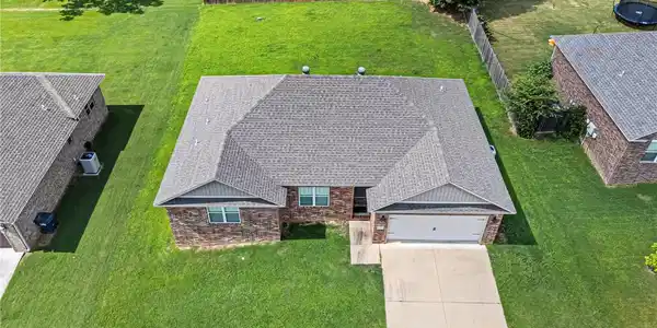 Image 3: Brick exterior home featuring a grey shingle roof,