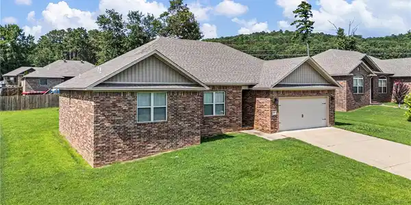Image 4: Brick exterior home featuring a concrete driveway