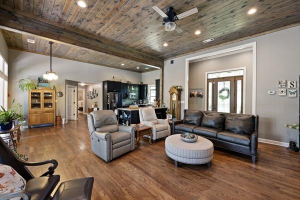Image 2: Spacious open-concept living area featuring wood-f