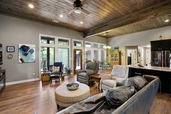 Image 3: Spacious living area featuring wood-finish floorin