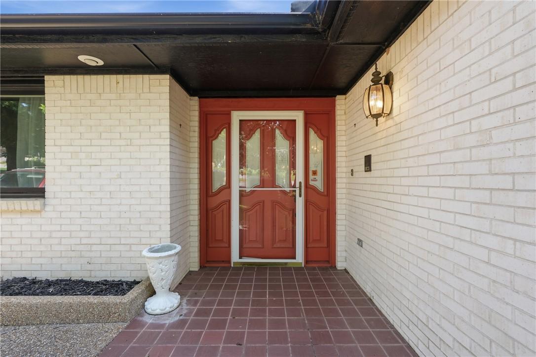 Image 2: Entryway featuring a vibrant red door with glass i