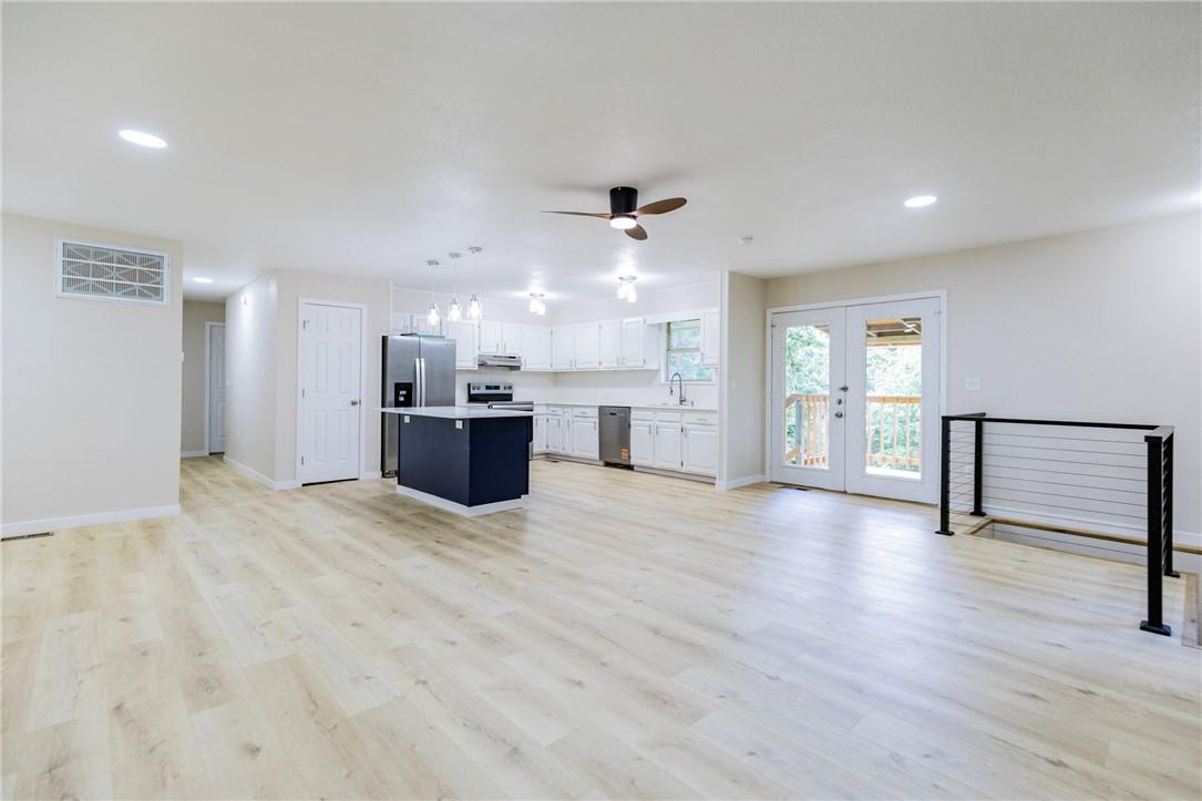 Image 4: Open-concept living area featuring light wood-fini