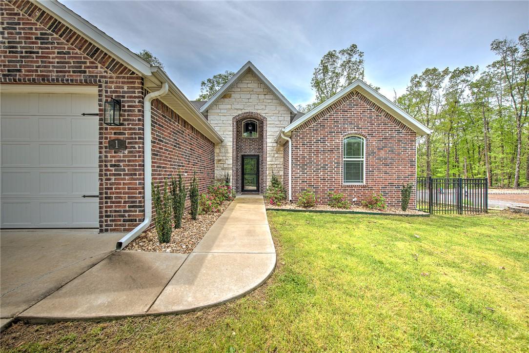 Image 2: The property features a brick and stone facade, a