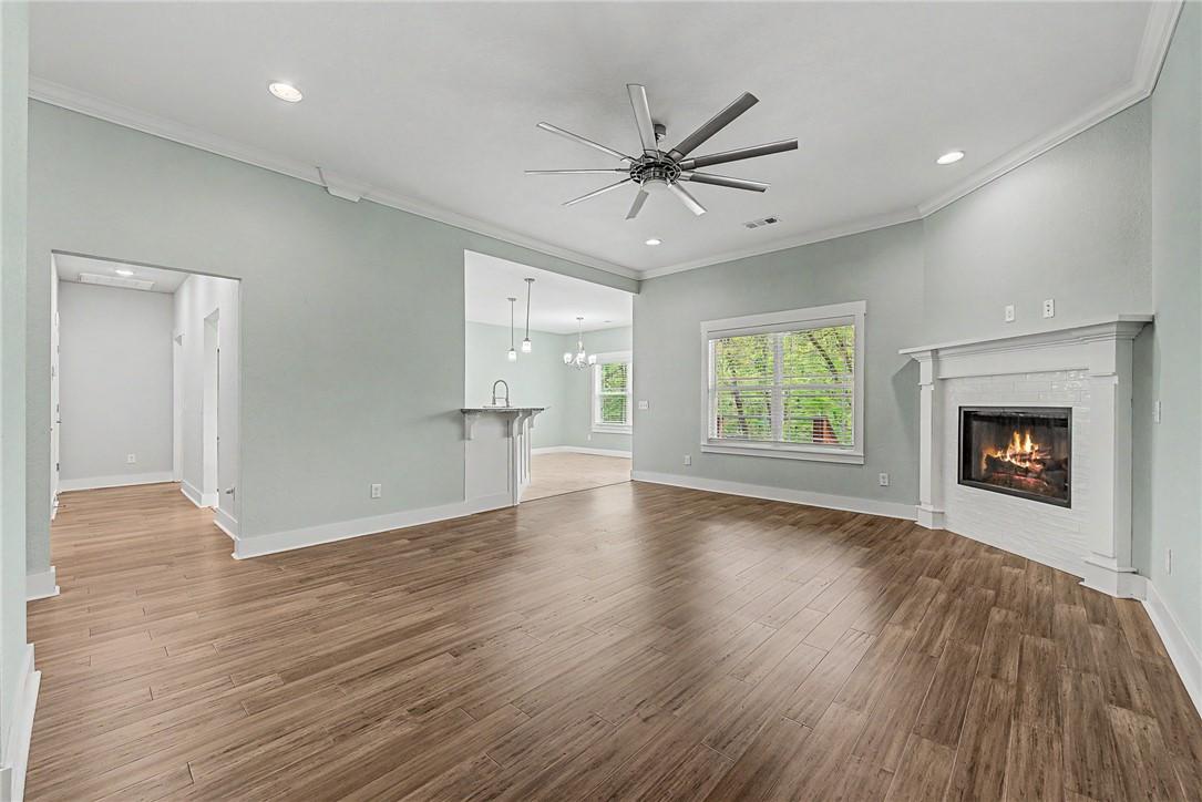 Image 3: The living area features wood-style flooring, a co