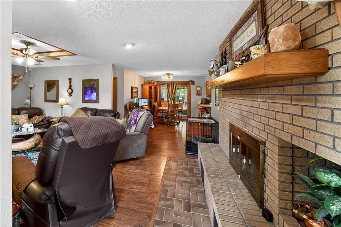 Image 3: Brick fireplace with a wood mantel and hearth, com