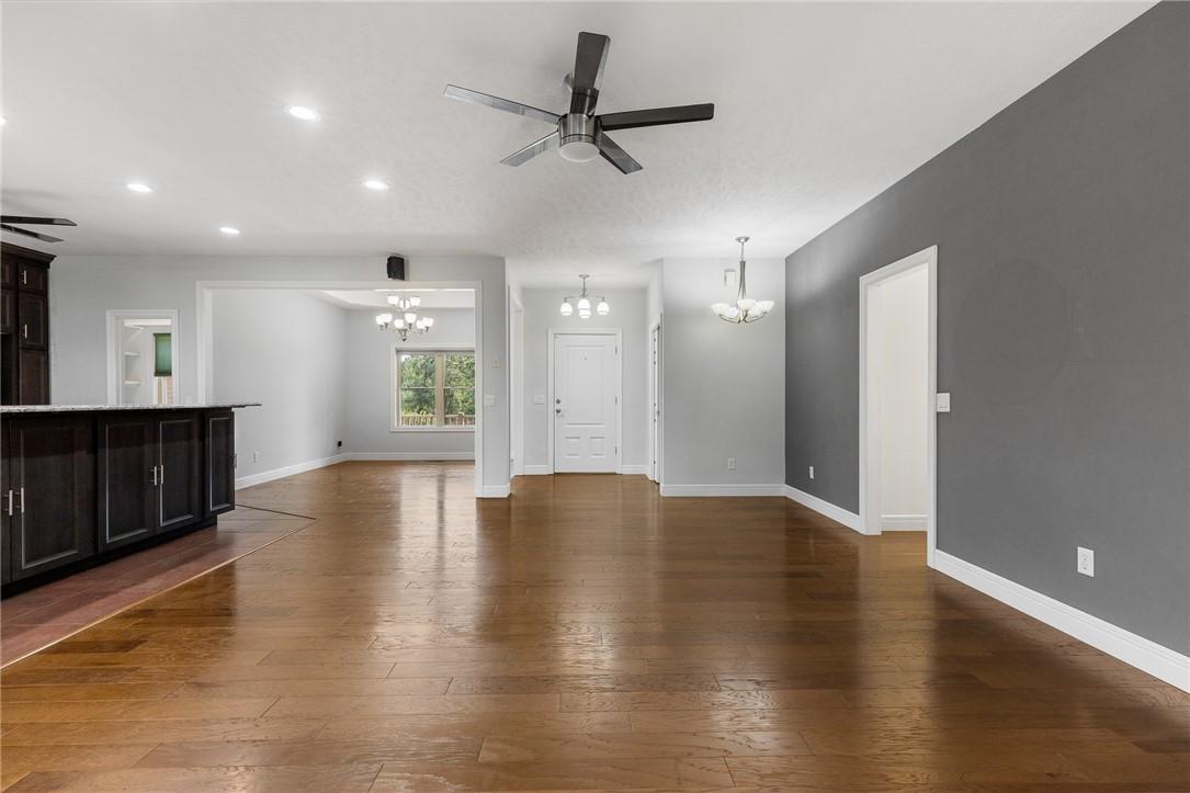 Image 3: Open concept living area featuring wood-finish flo