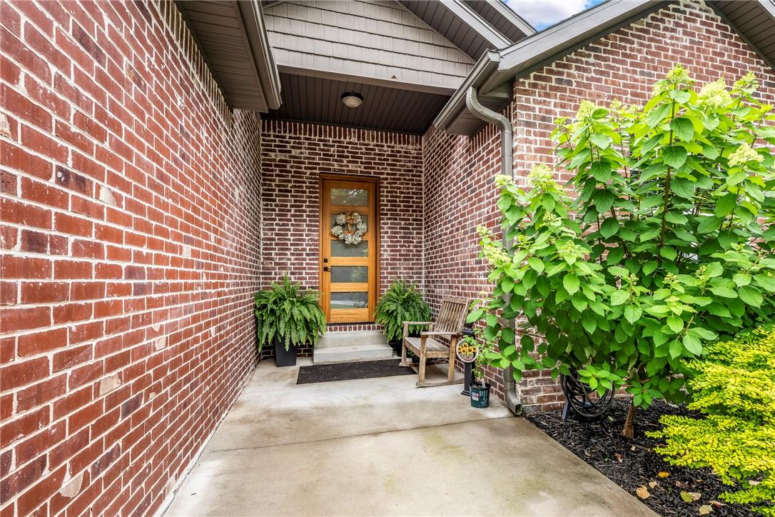 Image 2: Brick facade entry with a wood-panel door featurin