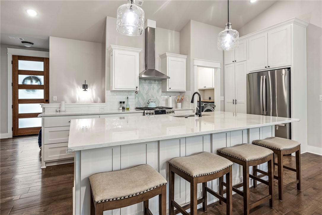 Image 3: Kitchen featuring a large central island with seat