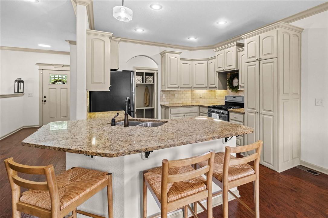 Image 3: Kitchen featuring a large central island with a gr