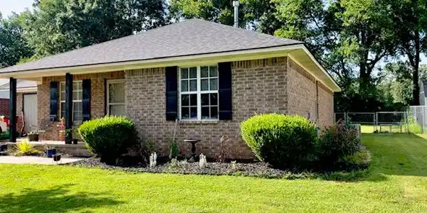 Image 2: Brick exterior residence with a dark shingle roof