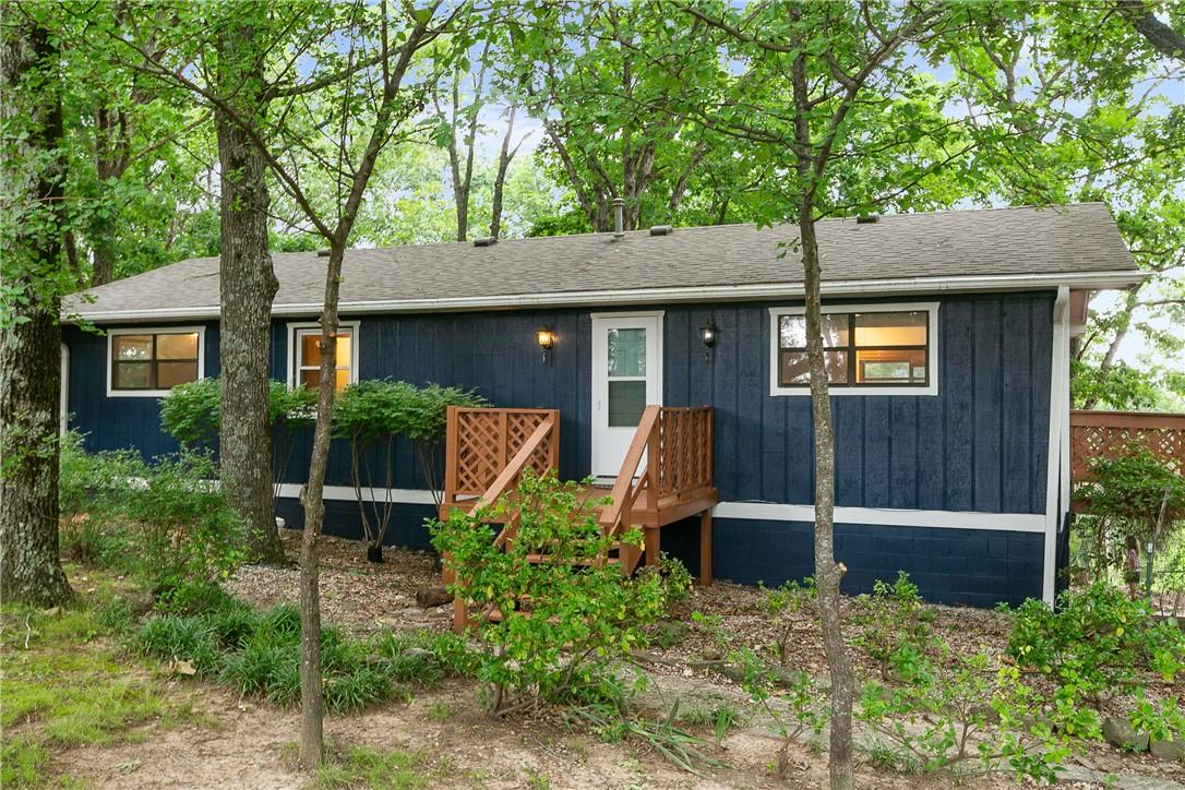 Image 1: Exterior featuring dark blue vertical siding, whit