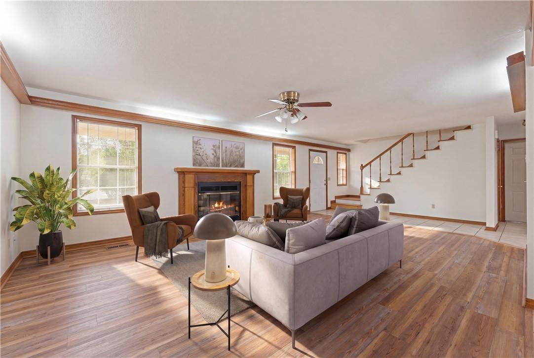 Image 3: Spacious living area featuring wood-finish floorin