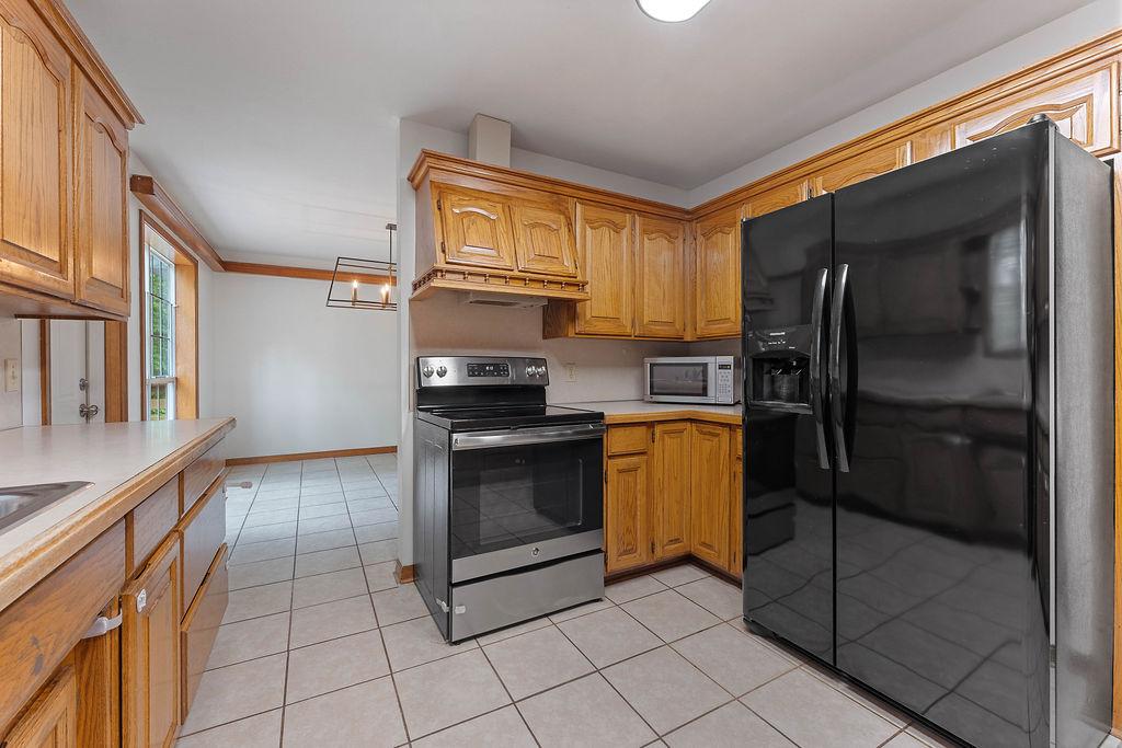 Image 4: Kitchen featuring wood cabinetry, light countertop