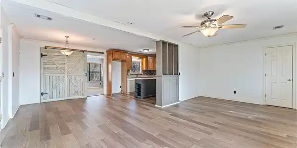 Image 4: Unfurnished living room with a barn door, ornament