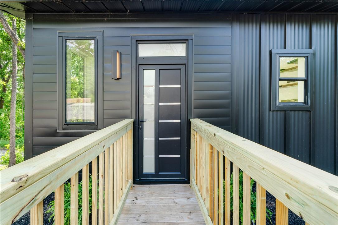 Image 2: Modern exterior featuring a dark entry door with f