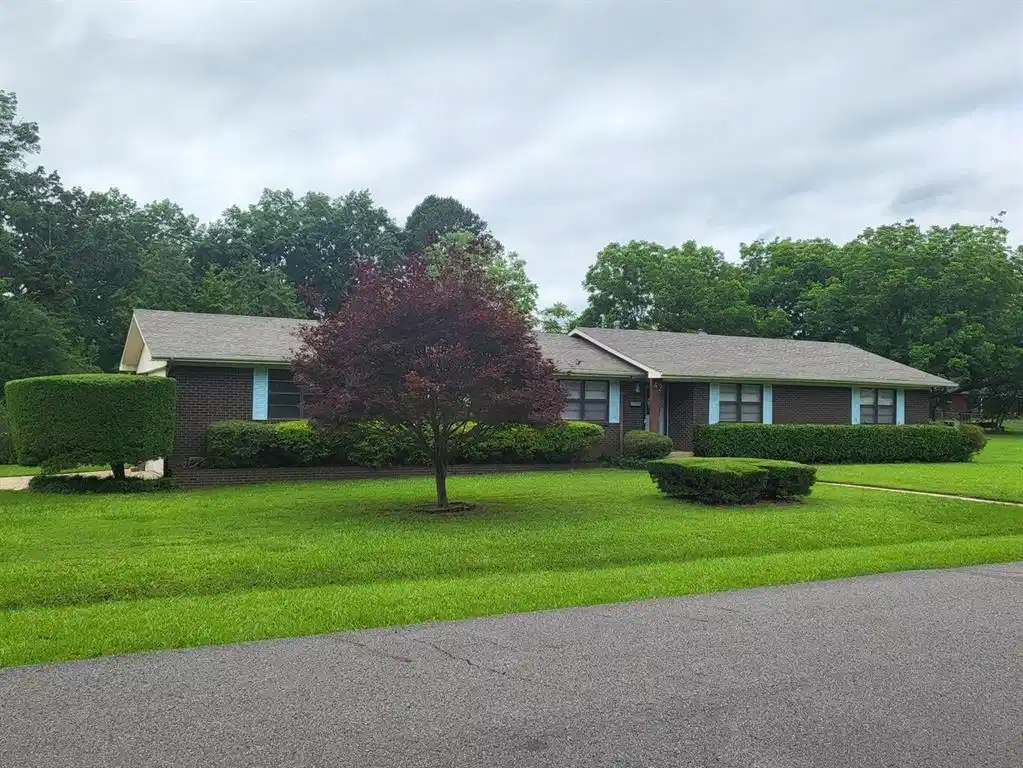 Image 1: Single story home featuring a front yard and brick
