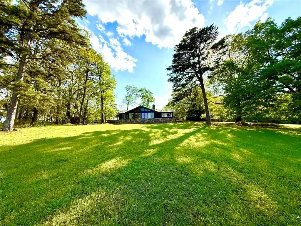 Image 1: View of green lawn with view of scattered trees, a
