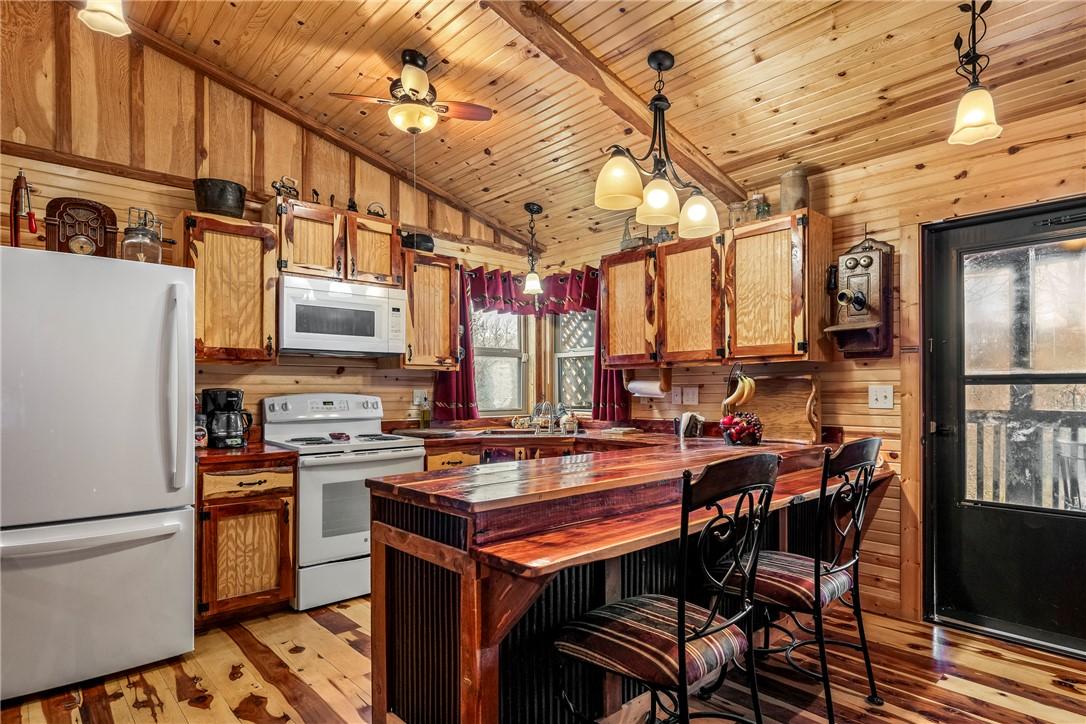 Image 3: Kitchen featuring white appliances, a kitchen brea