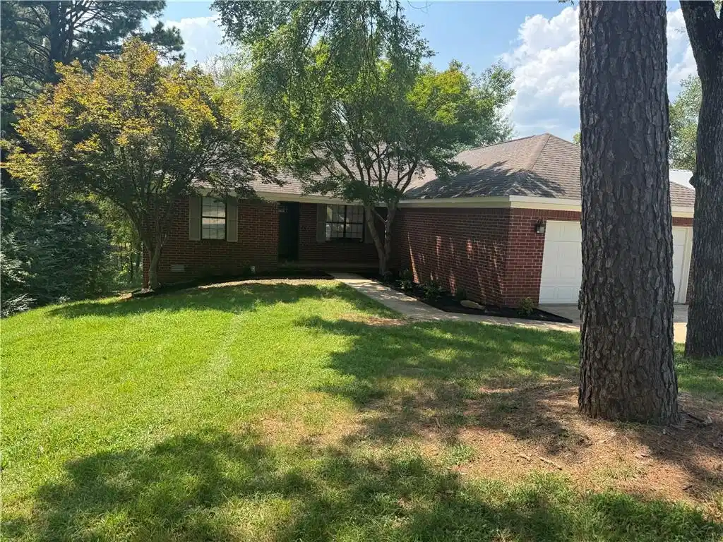 Image 1: Brick exterior with a shingle roof, two-car garage