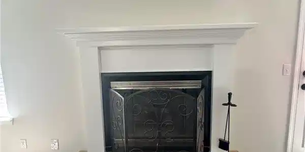 Image 4: Fireplace with a white mantel, black firebox, and