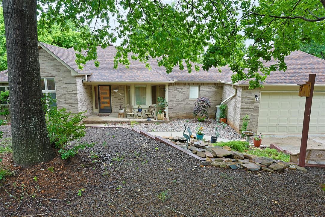 Image 2: Brick exterior featuring a covered front porch, a