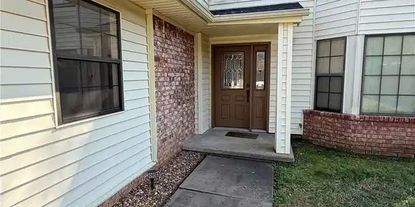 Image 2: View of exterior entry featuring brick siding