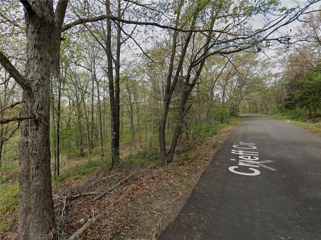 Image 3: View of asphalt street featuring a wooded view