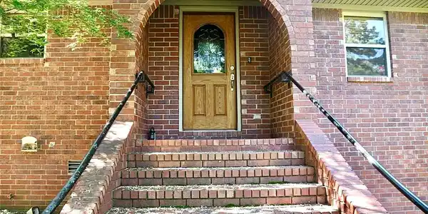 Image 2: Brick exterior with arched entryway and solid wood