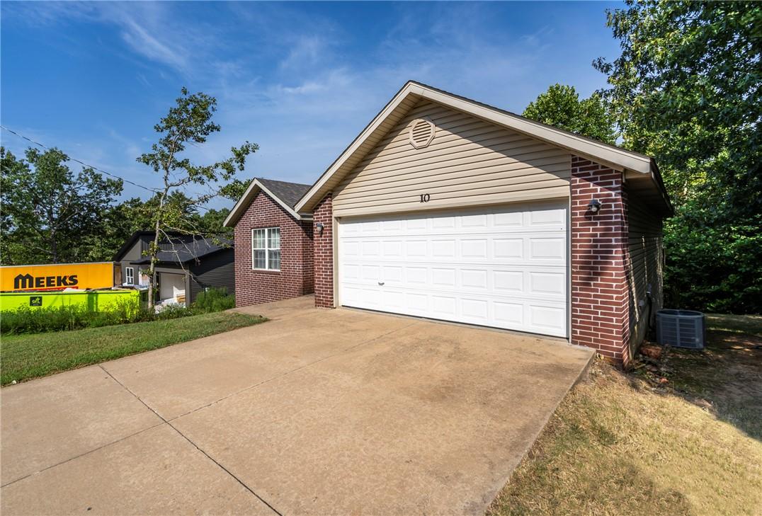 Image 2: Brick facade with vinyl siding accents, concrete d