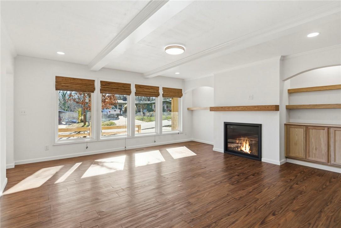 Image 4: Unfurnished living room with beamed ceiling, a gla