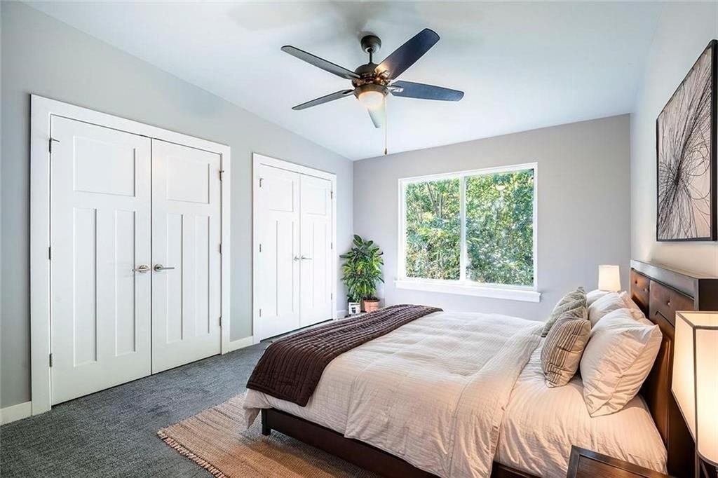 Image 2: Bedroom with two closets, carpet flooring, and a c